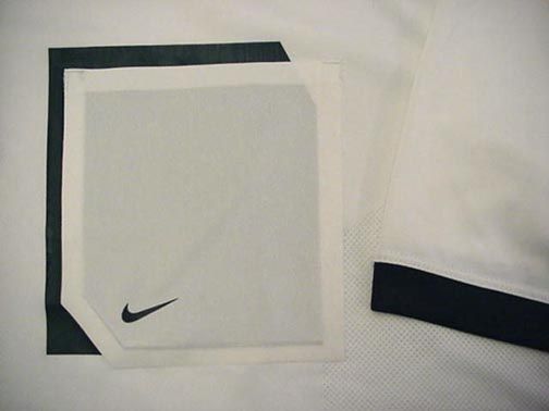 The sleeves are trimmed in College Navy. On the left chest is a 